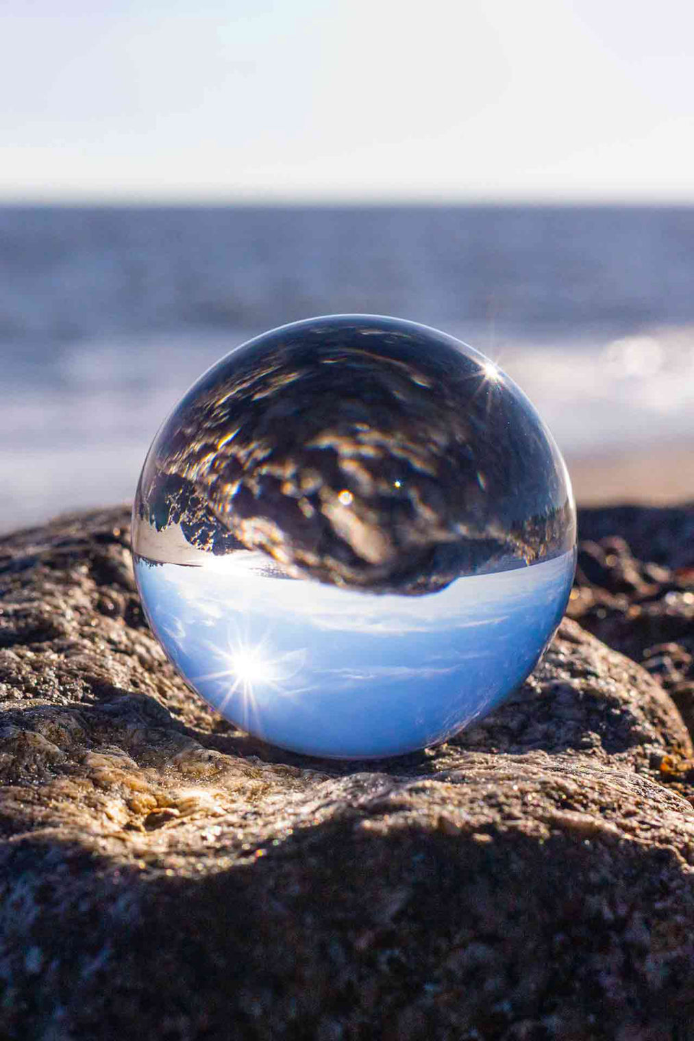 Glaskugel spiegelt den blauen Ozean 