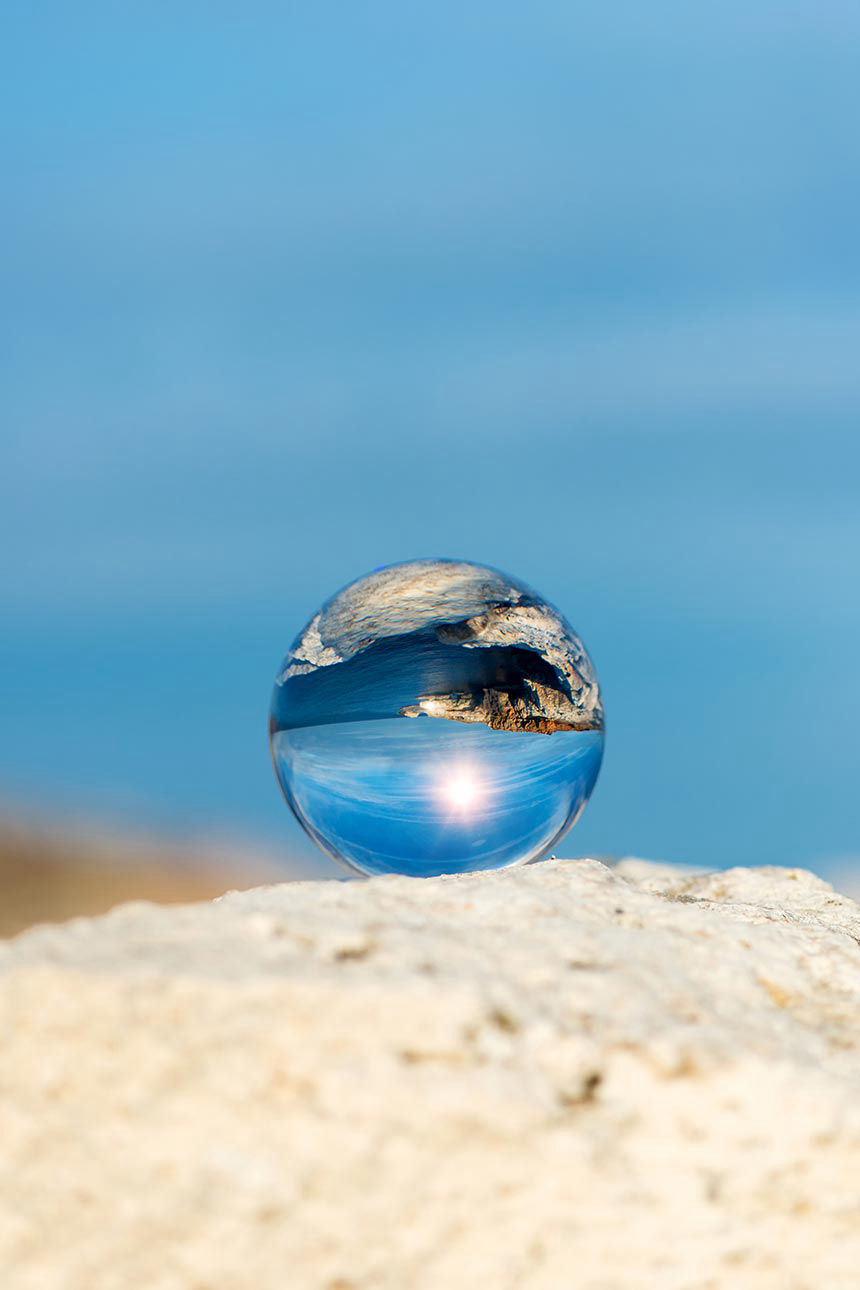 Glaskugel spiegelt den blauen Ozean 